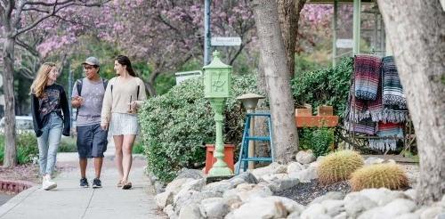 three students walk in the Claremont Village